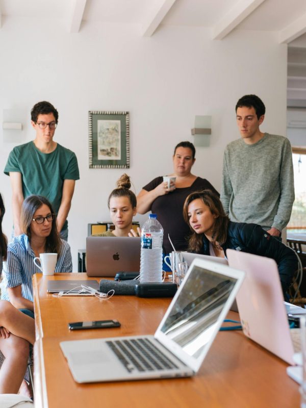 Group of young professionals engaged in a collaborative meeting in a modern office setting.